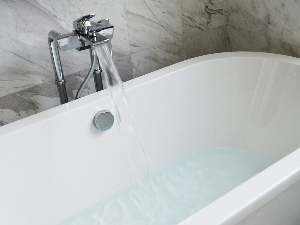 bathtub with running faucet